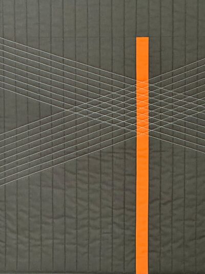 Gray quilt with orange stripe.